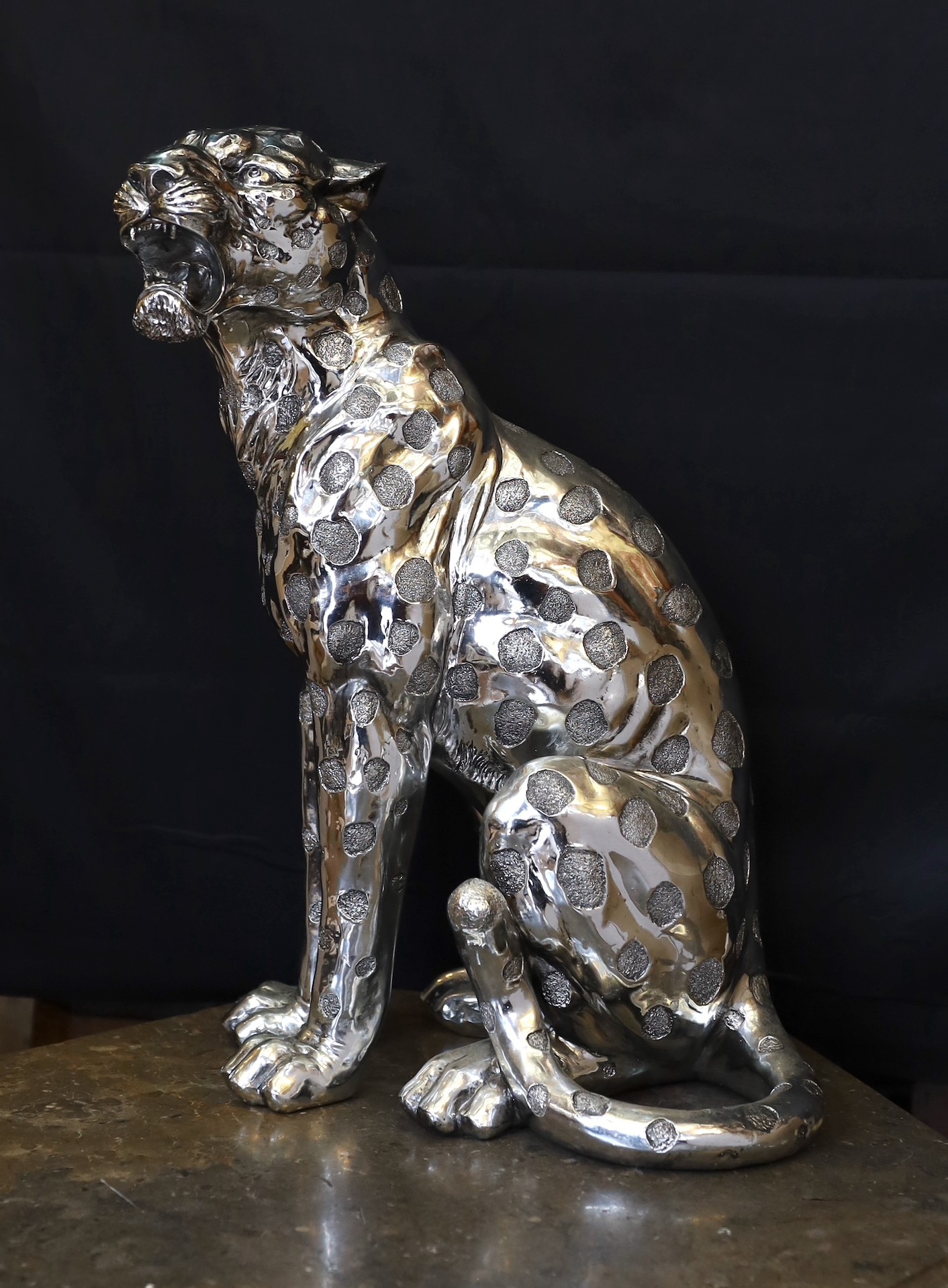 A silvered composition model of a seated leopard, height 50cm